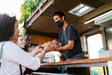 Food truck worker handing a plate to customers