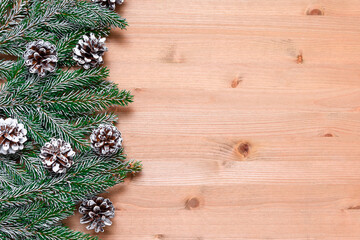Christmas decorations on a white wooden background with cones and fir branches.