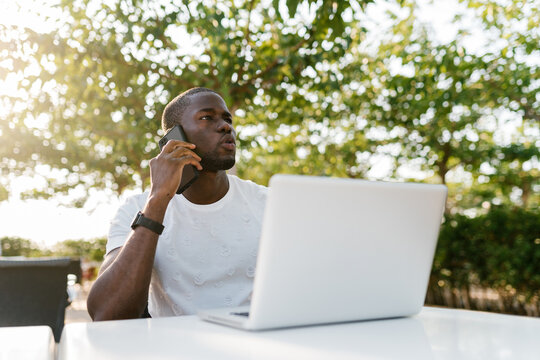 Man with laptop talking on phone