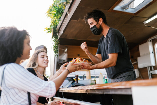 Seller serving nachos to diverse friends