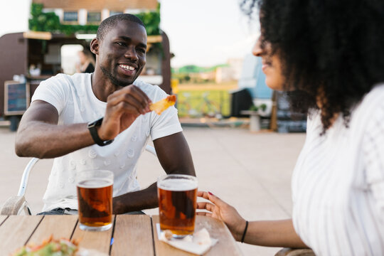 Man feeding woman with nachos