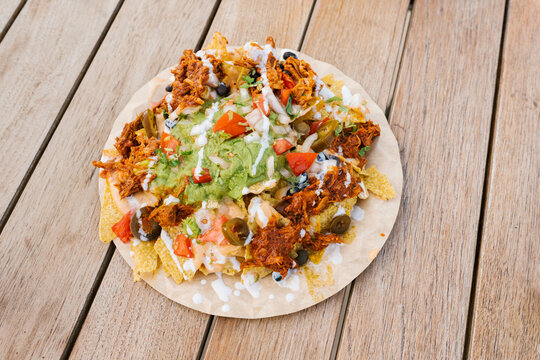 Plate of Mexican nachos on a wooden table