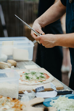 Grating cheese on a pizza