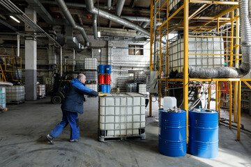 Worker pushing chemical tank