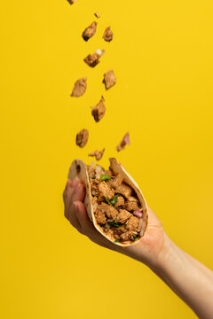 Hand holding Mexican pork tacos carnitas