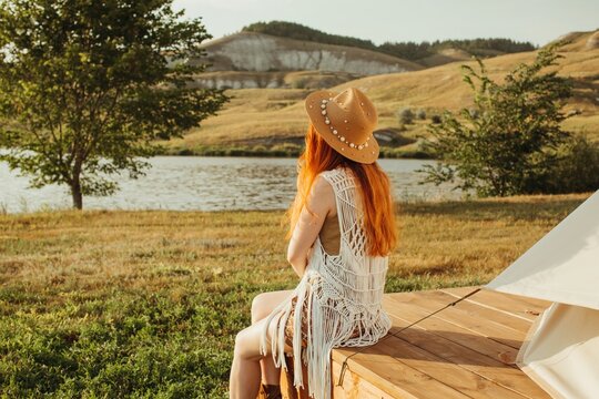 Anonymous woman looking at tree and river