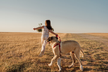 Young girl enjoying with her doggy outdoors
