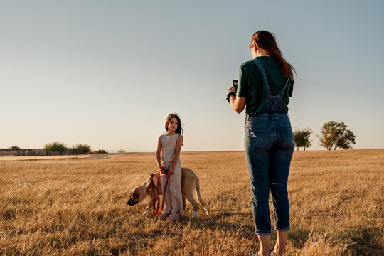 Kid posing with her dog for a pic at field