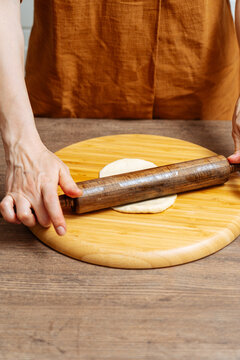 Crop woman chef making Indian flatbread at home