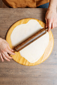 Crop woman chef making Indian flatbread at home