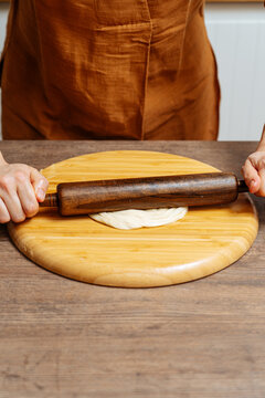 Crop woman chef making Indian flatbread at home