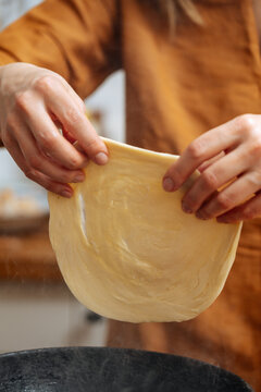 Crop woman chef making Indian flatbread at home