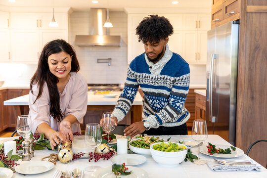 Man and Woman Set Christmas Dinner Table