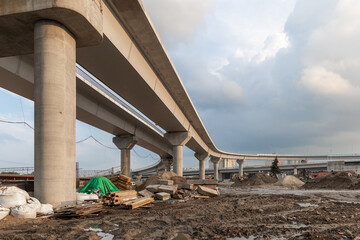 Construction of an urban multi-level road junction. Concrete overpass on high supports. The process...