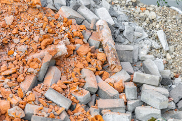 Construction garbage. A pile of red broken bricks, debris of concrete and rubble. Dust, dirt and stones after the demolition of the building