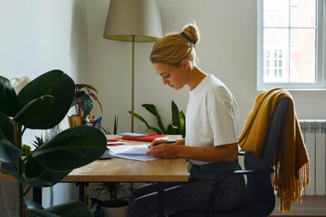 Young woman doing paperwork at desk