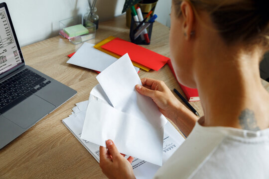 Woman opening letter over table
