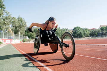 Female wheelchair athlete training on sports track