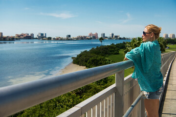 Young woman wearing glasses enjoys the view of the clearwater bay