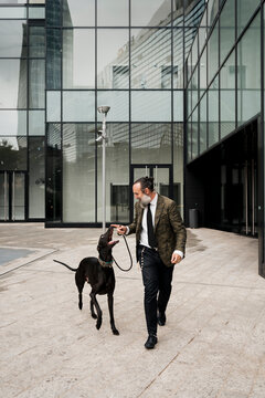 Adult Man walking outdoor with his dog in the city