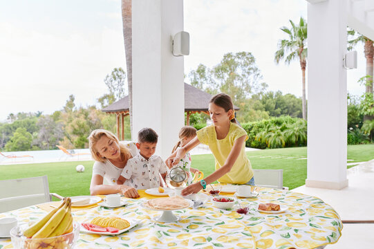 Family Eating Lunch Outside On Their Patio