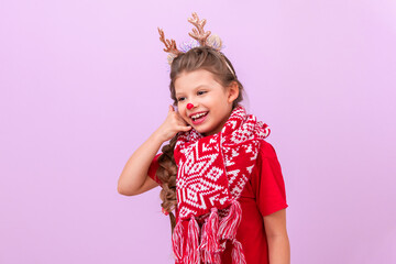 A little girl in a Christmas deer masquerade. shows hand gestures that she is calling on the phone.
