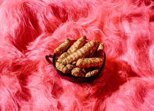 turmeric roots in a green glass cup