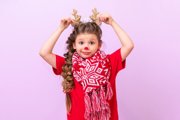 A little girl dressed as a Christmas deer holds her hands to the masquerade horns.