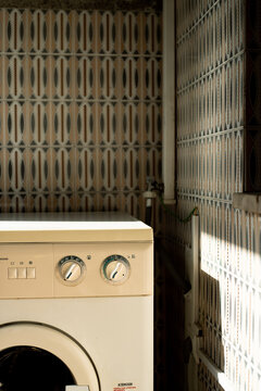 Laundry machine in a corner of the balcony with tiles