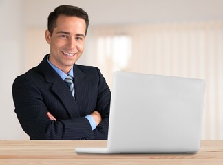 Emotional glad young employee looking at laptop screen, feeling excited