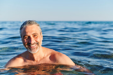 Smiling mature man floating in the ocean