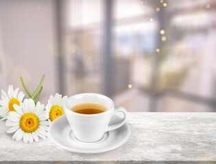Chamomile tea in a mug with natural small chamomile flowers