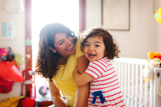 mother and daughter cuddling and smiling