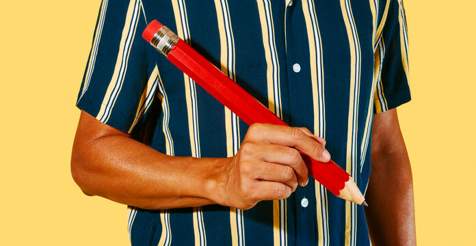 man about to write with a large red pencil