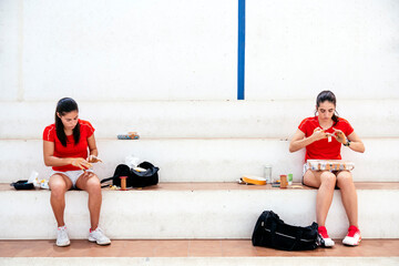 Two athlete women protecting her hands with tape to play traditional spanish game