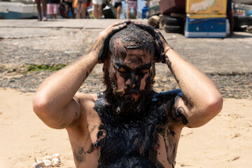 Man putting oil on himself in protest of oil spilled on the beaches of Brazil in 2019. Performance...