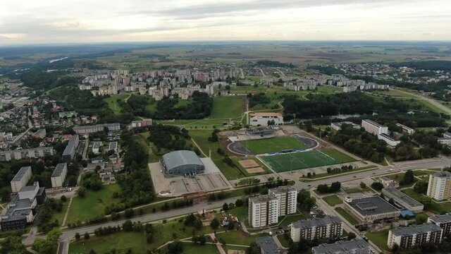 Football field and old block apartment buildings in cityscape of Jonava, aerial drone view