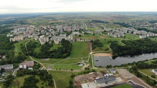 Small water dam in centre of Jonava city with apartment buildings around, high angle drone view