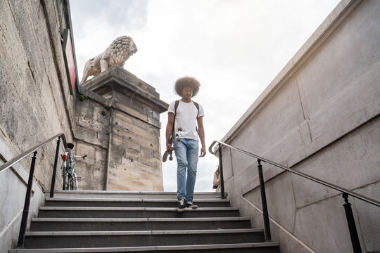 Man Carrying Skateboard Going To Metro