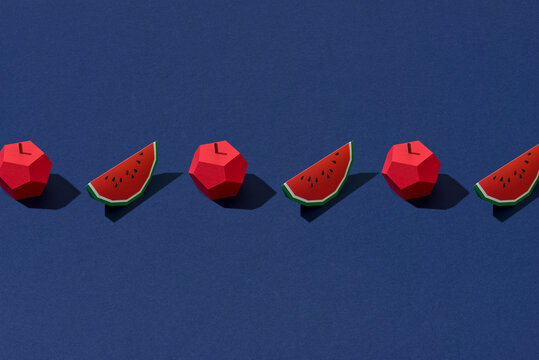 origami watermelon and apple on blue paper
