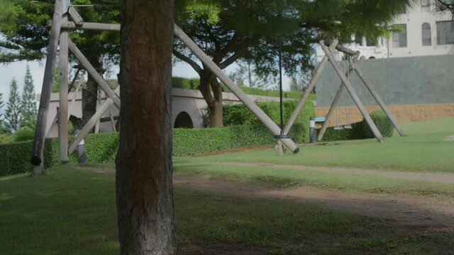 Asian girl playing on the rope swing come down from high that provides a lot of fun, excitement and happiness.