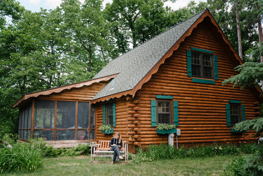 Woman Drawing By A Log Cabin