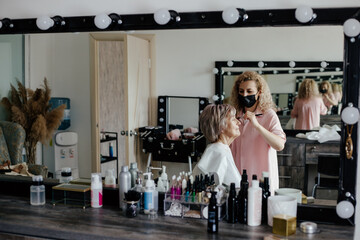 Aged woman getting makeup in salon