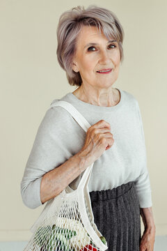 Senior woman with purchases in mesh bag