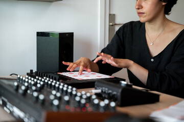 Woman playing midi controller at home music studio