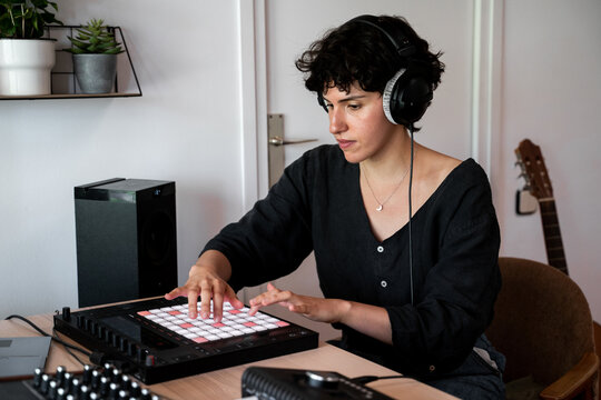 Woman playing midi controller at home music studio