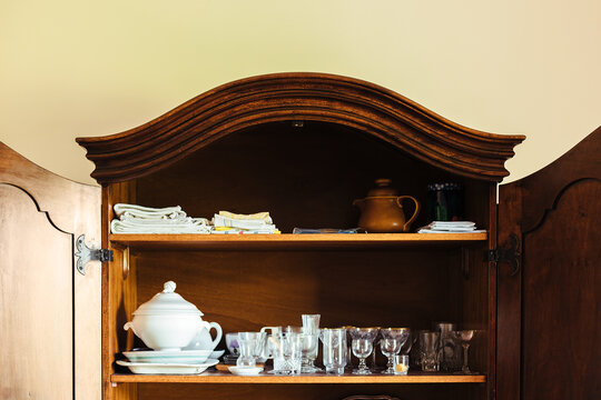 Open wooden cupboard with glasses