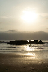 Sunset on the Beach with a big rock in the sea 