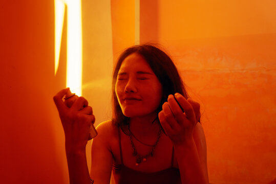 young woman spray sunscreen spray