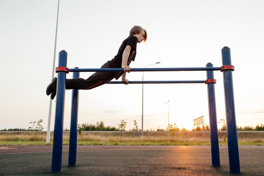 Teen boy exercising on parallel bars